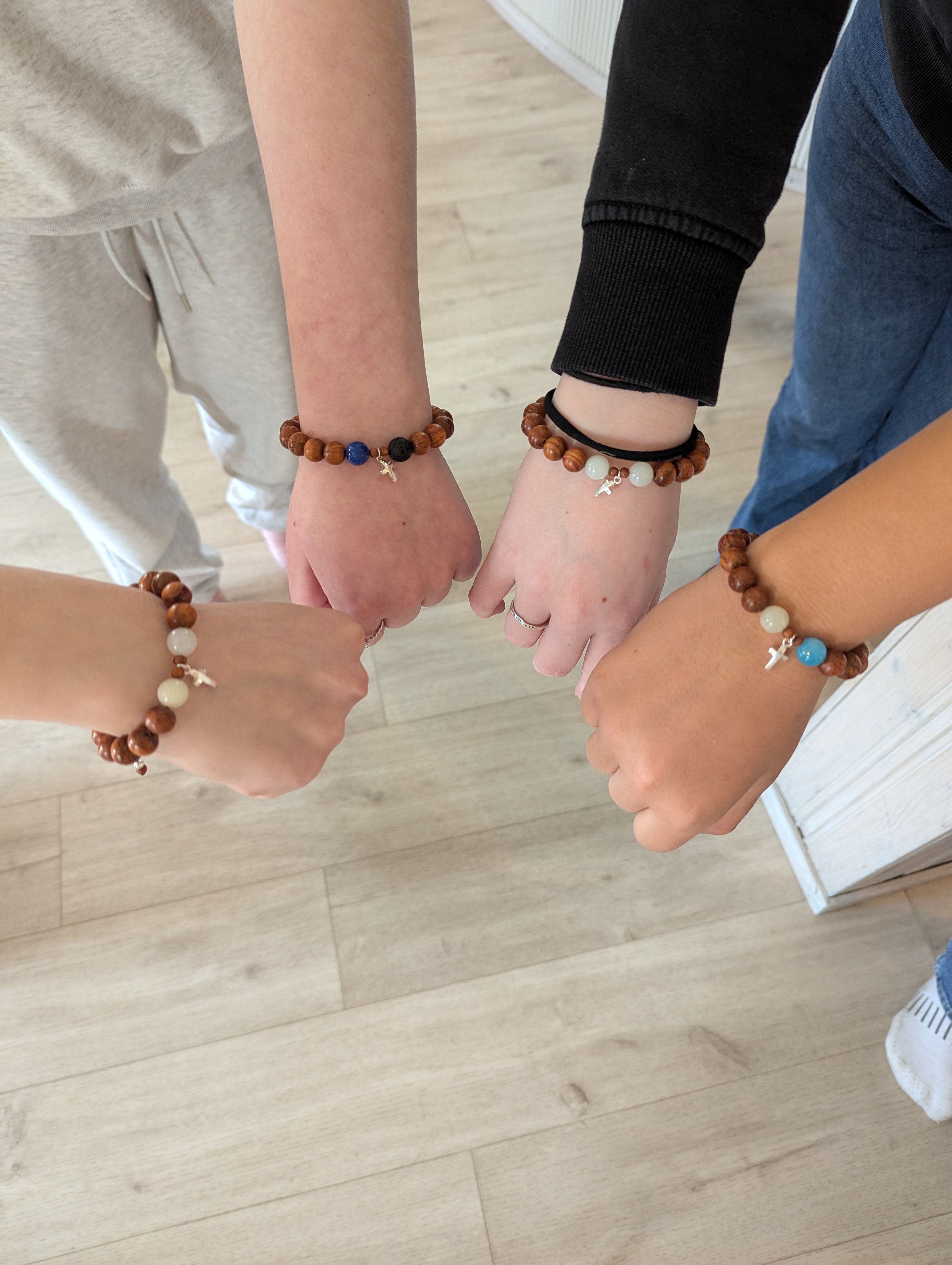 Konfirmander visar armband med silverkors